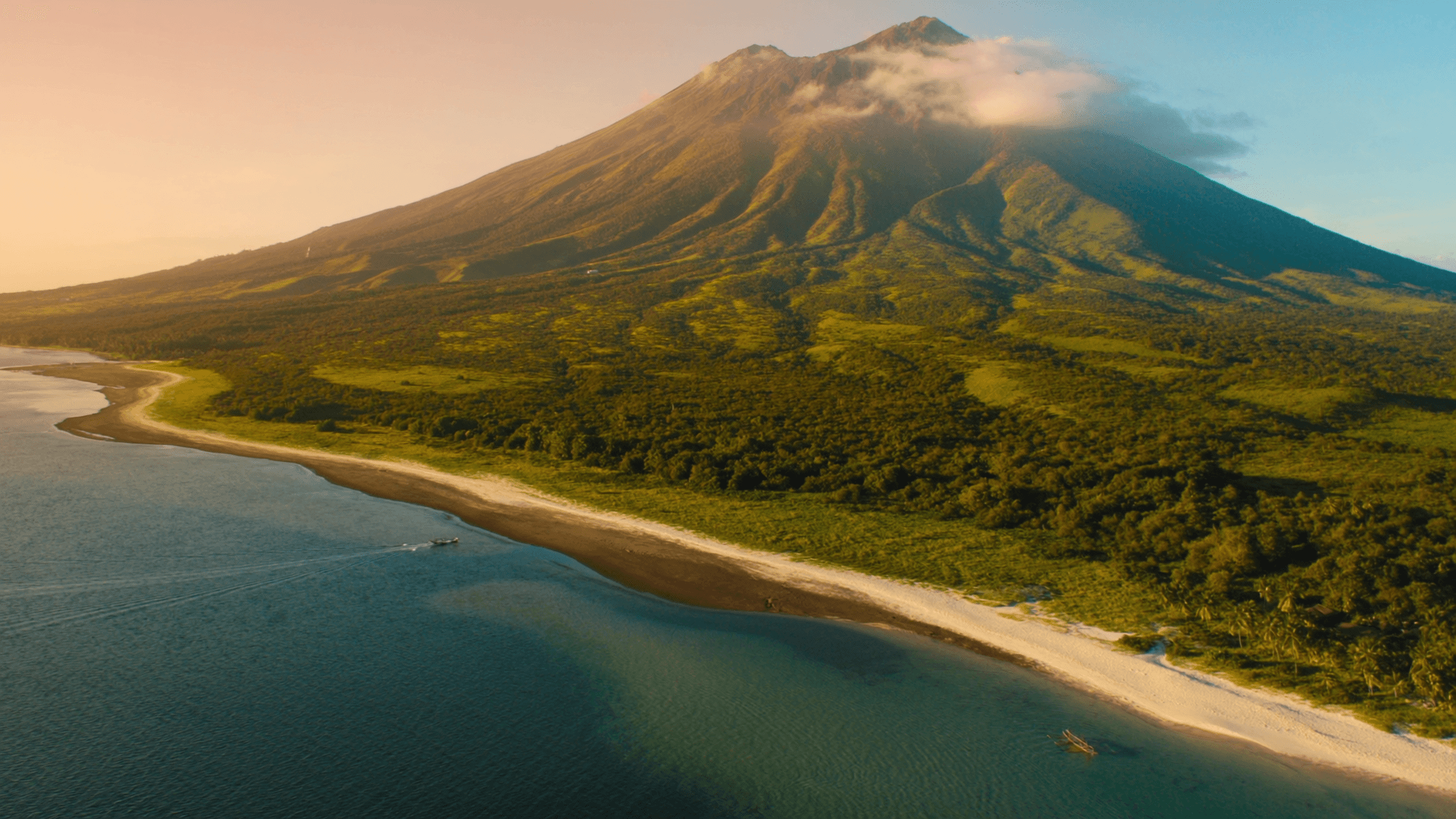 Camiguin vs Siquijor — the volcanic Camiguin coastline seen from the air, with White Island and the Bohol Sea